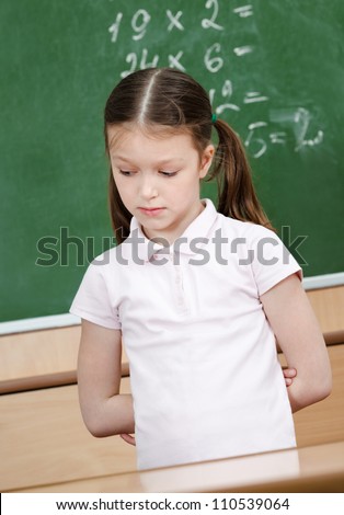 Pupil doesn\'t know the answer and she is ashamed of it. She puts her hands behind the back