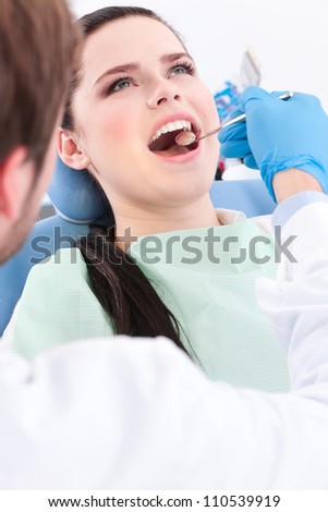 Dentist detects the carious teeth of the patient on the dentist\'s chair