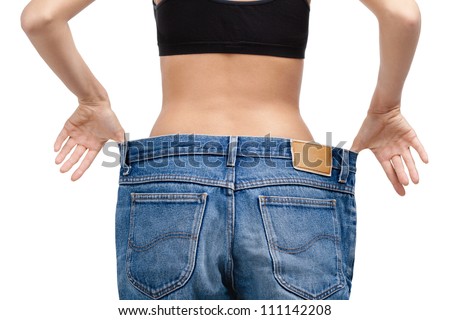 Body of a slim girl wearing enormous jeans, isolated on white