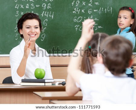 Beautiful teacher questions pupils at algebra