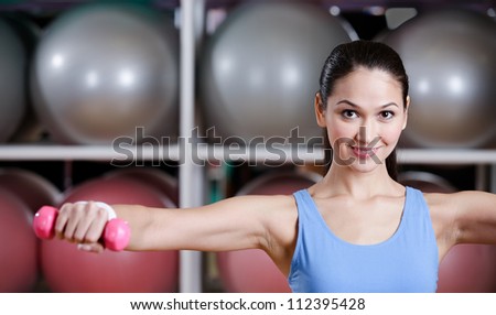 Sportive woman training with dumbbells in gym. Gymnastics