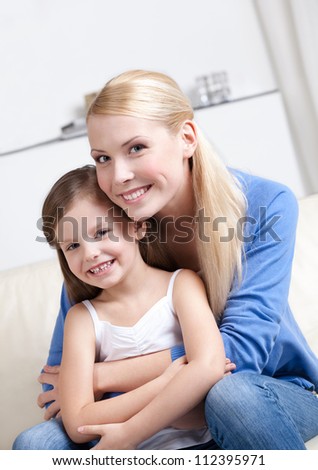 Smiley mother embraces her lovely daughter