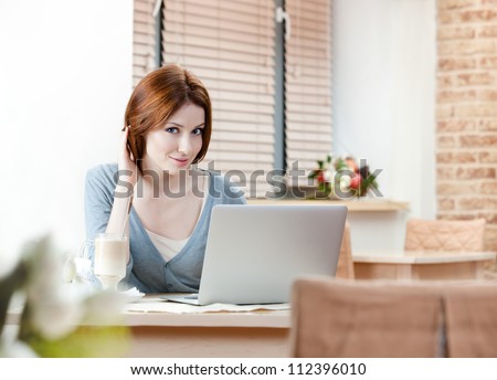 Woman is working on the personal computer at the internet cafe