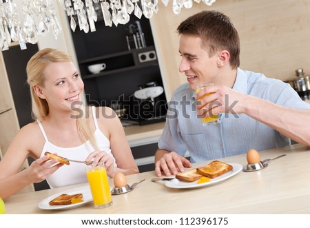 Husband and wife have a snack in the modern comfortable kitchen