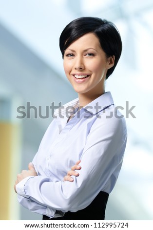 Portrait of a handsome successful business woman wearing white shirt and black skirt at business centre