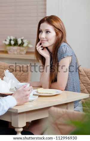 Lady talks with man sitting at the table at the restaurant