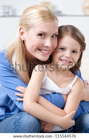 Smiley mother embraces her daughter