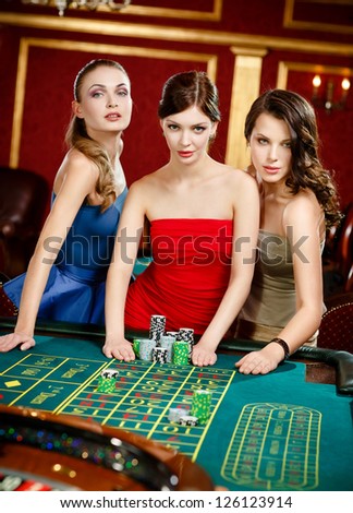 Three women place a bet playing roulette at the gambling house