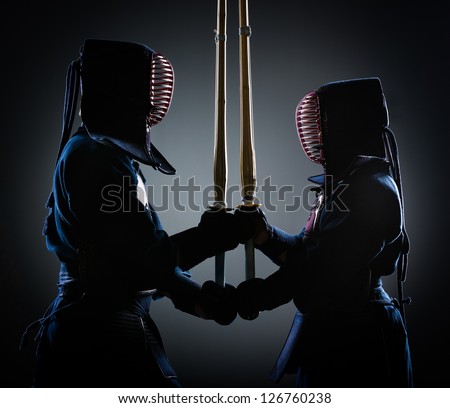 Two kendoka opposite each other with wooden sword. Japanese martial art of sword fighting