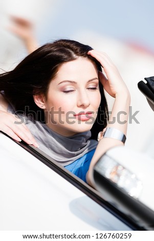 Close up of smiley woman with her eyes shut in the car