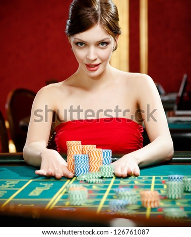 Playing roulette woman places a bet at the casino