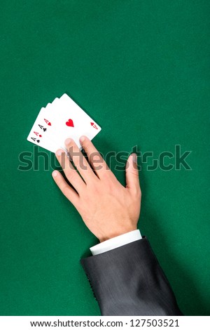 Hand with aces on the green table. Addiction to the gambling