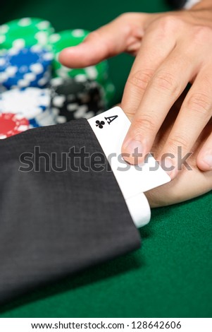 Poker player cheats with card from the sleeve. Risky entertainment of gambling