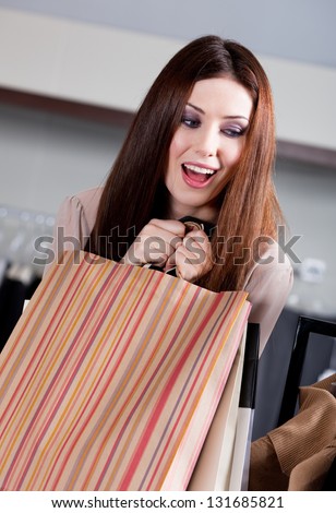 Woman doesn't want to let paper bags with gifts slip out of her hands
