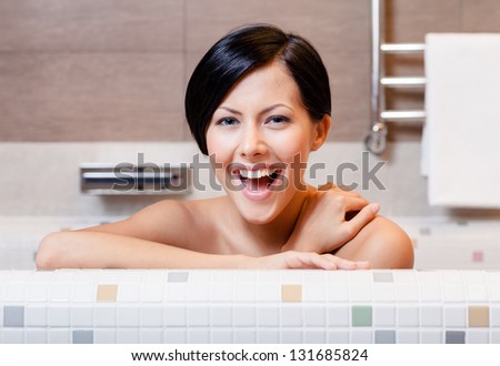 Beautiful woman relaxes in bathtub, hygiene concept