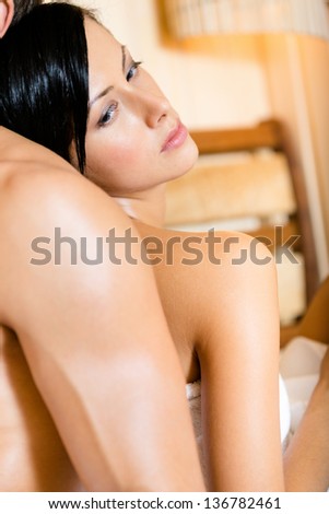 Close up of woman propping on man\'s back in sauna