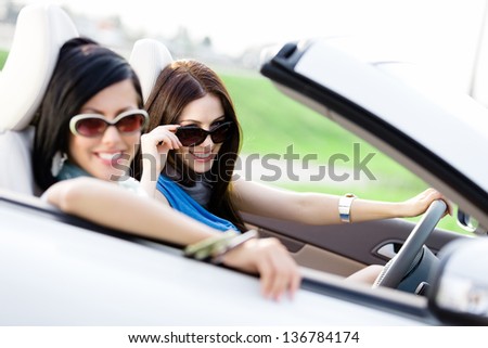Two happy friends in the car driving everywhere and looking for freedom and fun