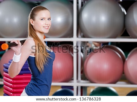 Sportswoman in sportswear works out with gymnastic stick