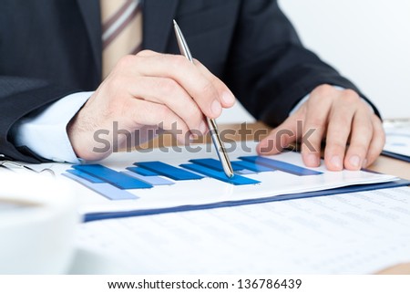 Business man working with diagrams. Close up of hands and documents