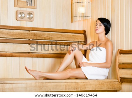 Half-naked girl relaxing in sauna. Concept of self-care, health and relaxation