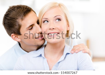 Man kisses the cheek of smiley blonde woman