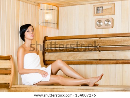 Half-naked woman relaxing in sauna. Concept of self-care, health and relaxation