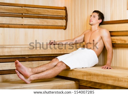 Half-naked young man relaxing in sauna. Concept of self-care, health and relaxation