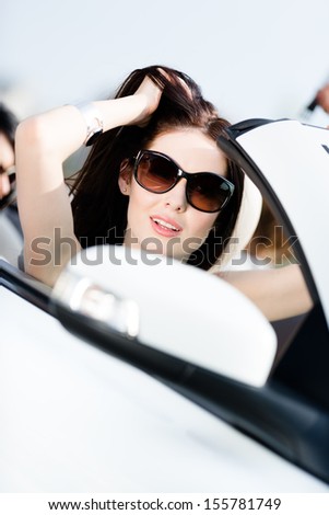 Close up of pretty female driver in the white convertible car