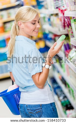 Girl at the store choosing cosmetics among the great variety of products. Concept of consumerism, retail and purchase