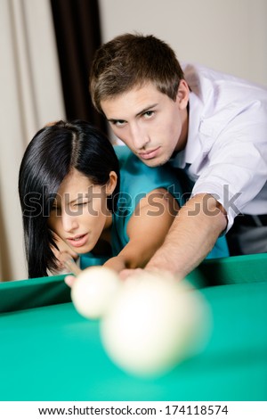 Man teaching lady to play billiards. Spending free time on gambling