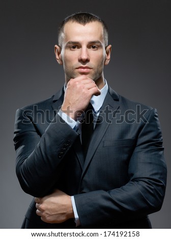 Pensive and self-confident manager props head with hand