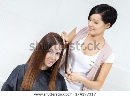 Hair stylist cuts hair of woman in hairdresser\'s. Concept of fashion and beauty