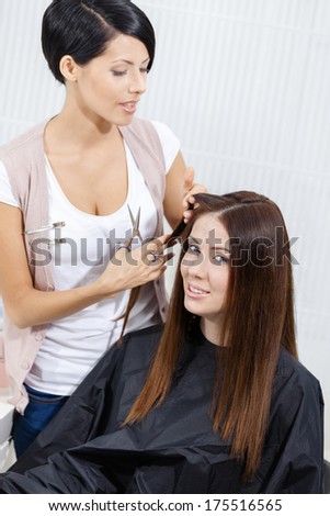 Hairdresser cuts hair of woman in hairdressing salon. Concept of fashion and treatment