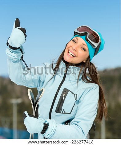 Half-length portrait of female downhill skier thumbing up. Concept of winter sports and cute entertainment
