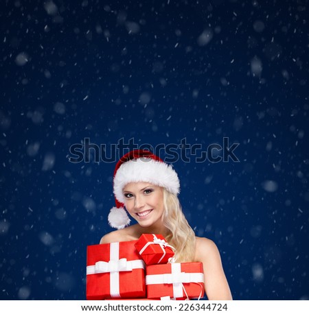 Beautiful lady in Christmas cap holds a set of gifts wrapped with red paper,winter background