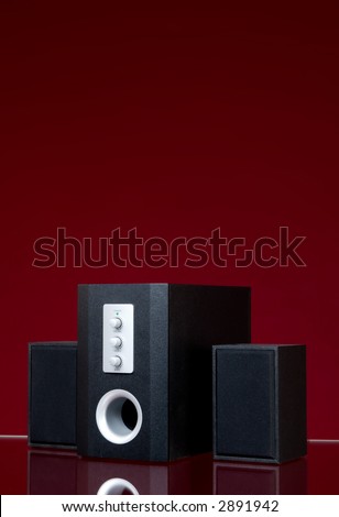 Audio speakers on the red background with reflection