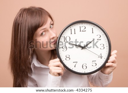 Young woman with clock isolated on beige background