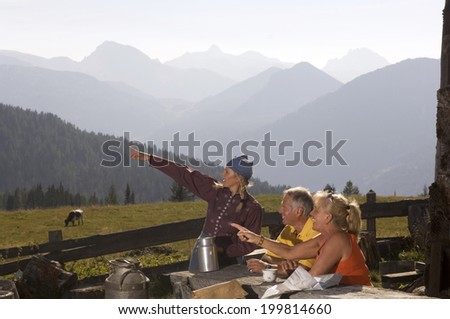 Couple at mountain hut, talking to peasant woman