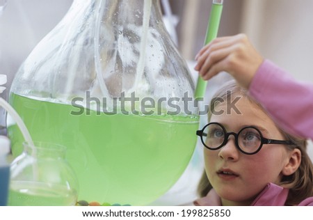 Girl in chemical lab, looking at test tube