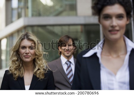 Three business persons standing smiling