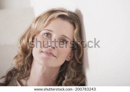 Woman leaning against wall portrait close-up