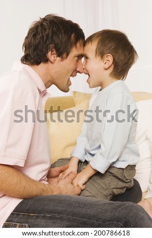 Father and son fooling about rubbing nose together