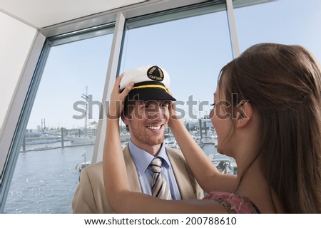 Germany, Hamburg, Woman putting sailor\'s cap on man