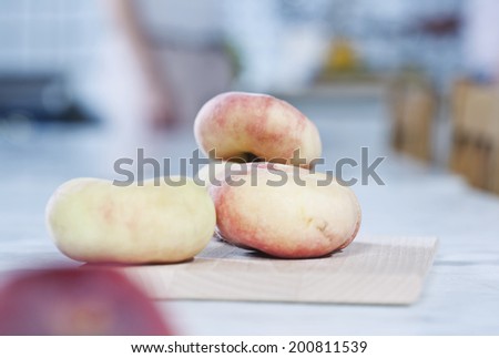 Italy, Tuscany, Magliano, Close up of flat peaches on chopping board