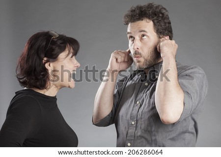 Mature couple quarreling woman shouting man covering ears