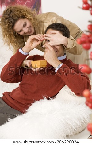 Woman giving Christmas present to man
