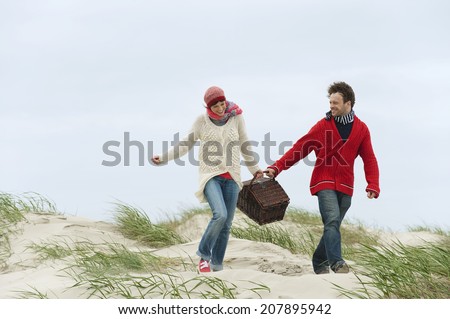 Germany St.Peter-Ording North Sea couple holding picnic basket walking on beach