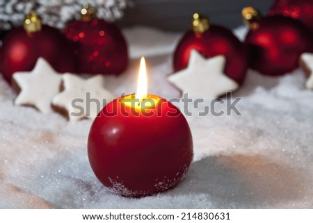 Christmas bulbs cinnnamon stars candle on pile of snow