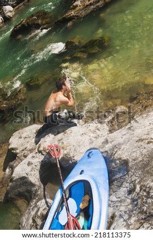 Austria, Salzburger Land, Young man washing face in Lammer river
