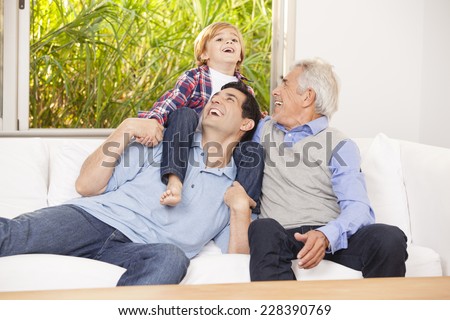 Grandfather, father and son at home together
